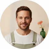 Portrait of Julian Thorne, a man with a friendly expression, wearing Aureon overalls against a clean cream background.