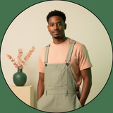 Circular portrait of influencer Tyler Woods, a man with short brown hair and a beard, wearing Aureon overalls and looking con