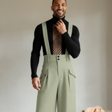 Kobe Wright, a man, smiles while wearing the Aureon overall, captured from the chest up against a cream background.